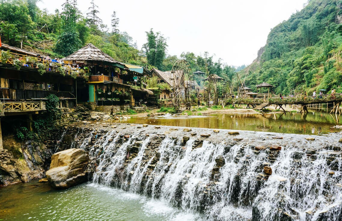 Cat Cat waterfall surrounded by traditional village scenery
