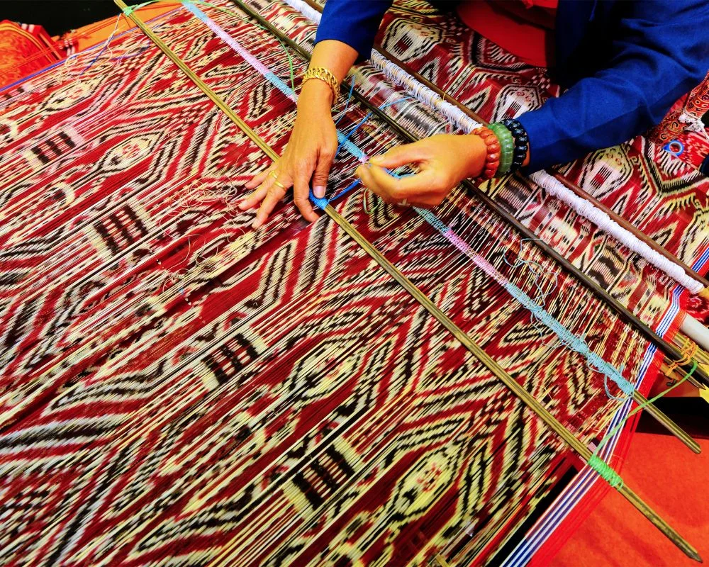 Local artisan weaving traditional fabric in a Sapa village